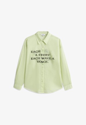 Jasnozielona, długorękawowa koszula na guziki z kołnierzykiem, z czarnym napisem "EACH A STORY EACH WAVE A VOICE" oraz subtelnym kwiatowym wzorem za tekstem.