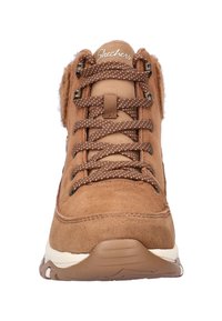 Bruine suède sneakers met een gewatteerde kraag, voorzien van polkadot veters, metalen ooggaten en een gestructureerde rubberen zool. Zachte voering zichtbaar.