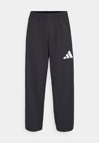 Sort sweatpants med en afslappet pasform, der har en elastisk talje og et hvidt geometrisk logo på venstre ben. Glat stoftekstur.