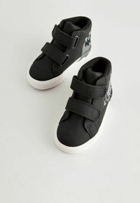 Scarpe alte nere con cinturini in Velcro, materiale liscio, suole bianche e dettagli grafici giocosi in grigio e blu sui lati.