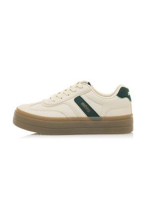 Zapatilla beige con acentos verdes, parte superior sintética lisa, punta redonda, suela de goma plana y cordones. Diseño simple con un perfil bajo.