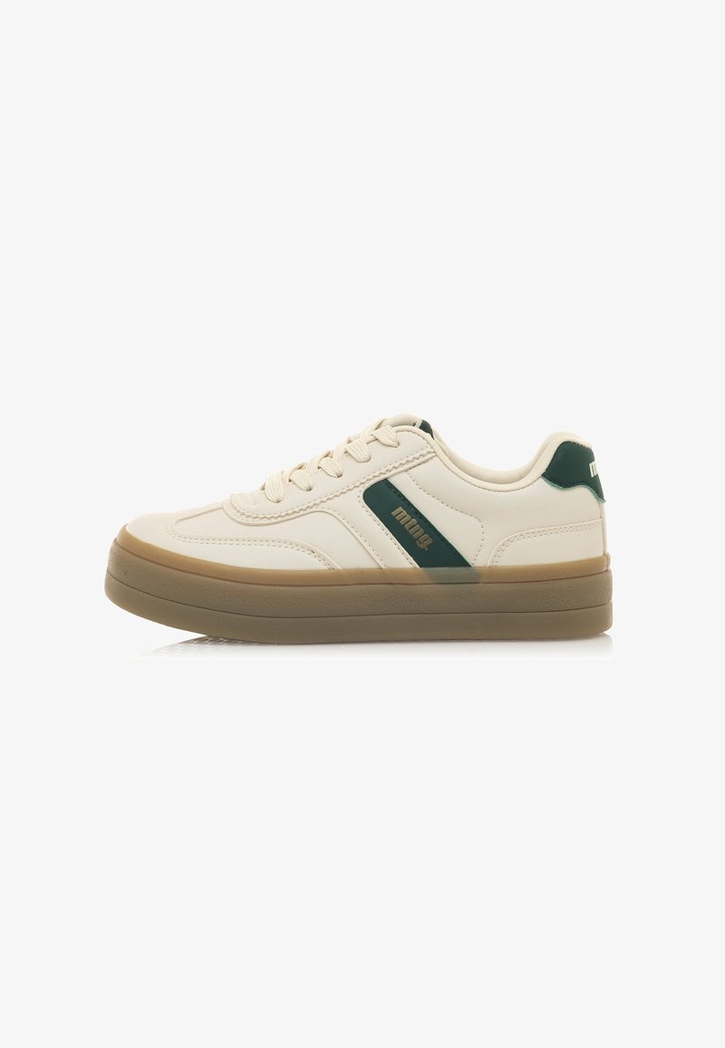 Zapatilla beige con acentos verdes, parte superior sintética lisa, punta redonda, suela de goma plana y cordones. Diseño simple con un perfil bajo.