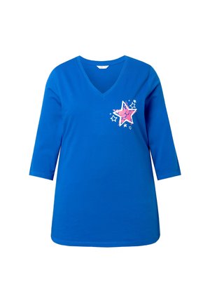 Camiseta azul de cuello en V con mangas tres cuartos. Presenta un gráfico de estrella rosa y estrellas blancas alrededor en el lado izquierdo. Material de algodón.