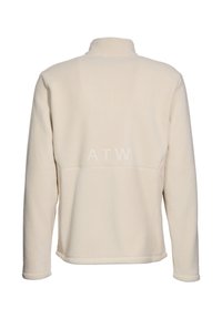 Krämfärgad fleece-tröja med hög krage, långa ärmar och subtil textdetalj "ATW" på baksidan. Mjuk textur med avslappnad passform.