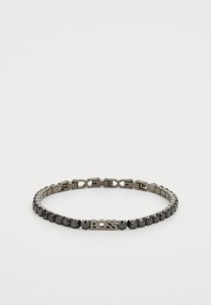 Metallist käevõru, millel on tumedad metallik lingid läbipaistvate aktsentidega, keskel logo "BOSS" ja poleeritud viimistlus.