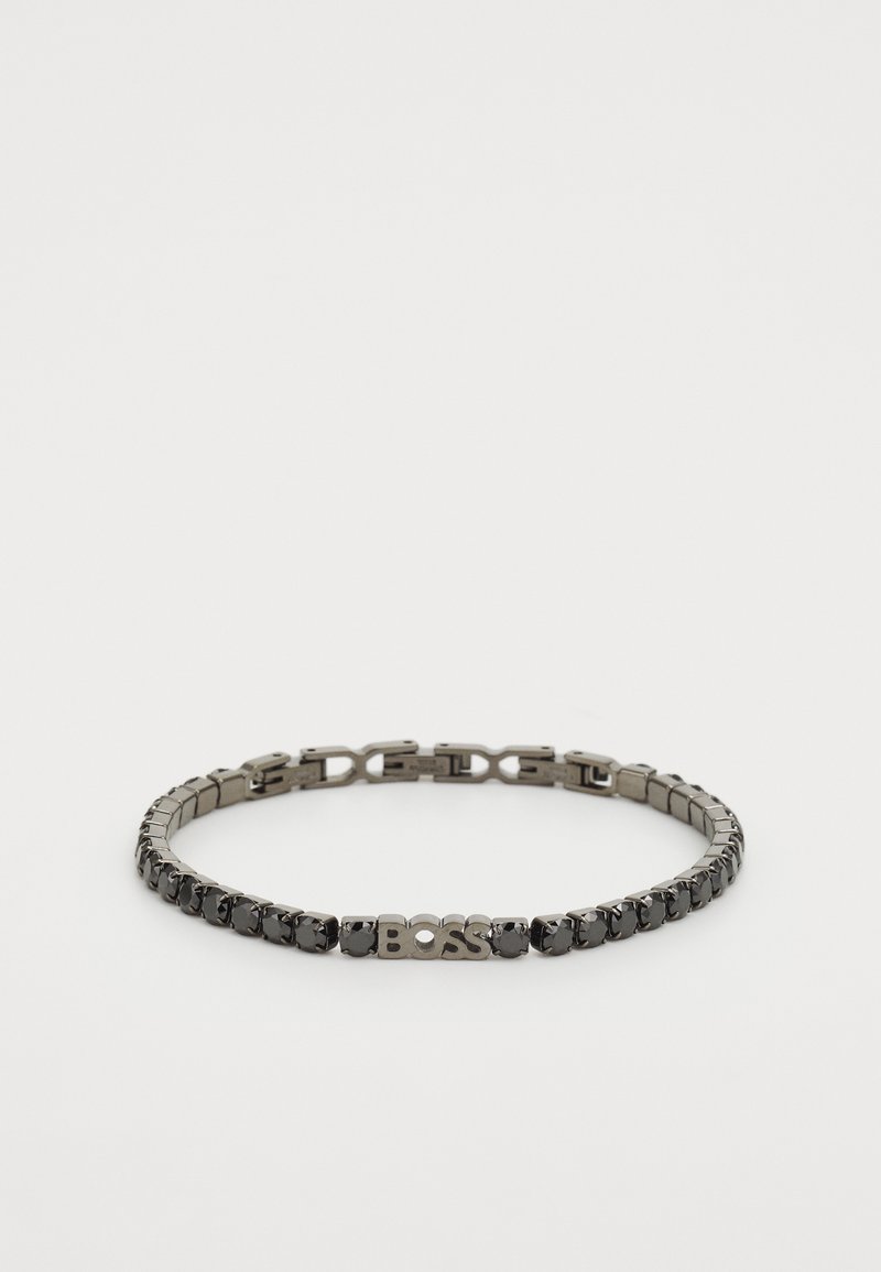 Metāla ķēdes rokassprādze ar tumšiem metāliskiem saitēm un caurspīdīgiem akcentiem, centrālais logo "BOSS" un pulēta apdare.