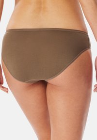Brown fabric bikini bottom with a smooth texture and low-rise design. Features seamless edges and moderate coverage.