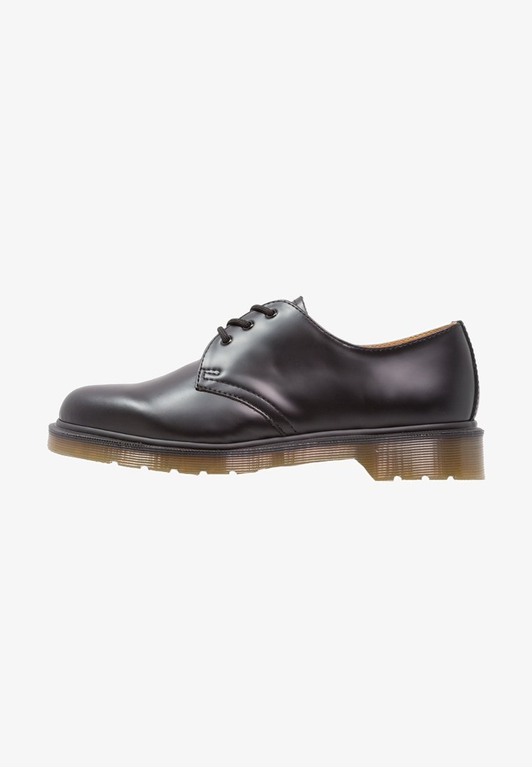 Chaussure en cuir noir avec bout arrondi, design à lacets, et semelle transparente texturée. Fini lisse avec des détails minimalistes de coutures.