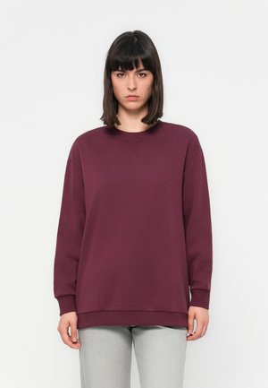 Bordeaux oversized sweatshirt met een ronde halslijn, raglanmouwen en lange mouwen. Gemaakt van zachte stof met een gladde textuur.