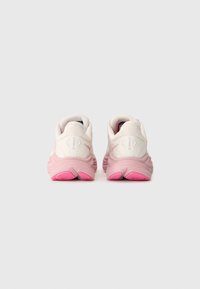 Hvite og rosa joggesko med en teksturert mesh-overdel, polstret krage og en rosa dempet såle. Har et distinkt mønster på sålen.
