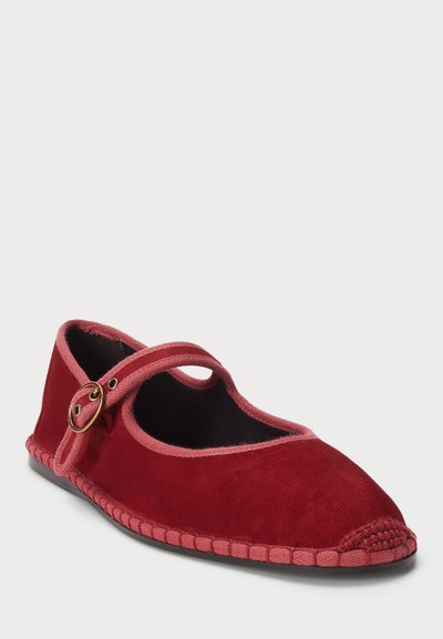 Chaussure plate en velours rouge avec un bout rond, dotée d'une sangle rose et d'un détail en métal doré. La semelle est noire avec un motif en texture tissée.
