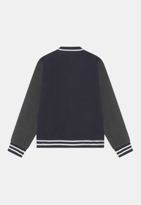 Tmavě modrá bunda se šedými rukávy, žebrovaným límcem a proužkovanými manžetami. Měkká tkanina se sportovním designem a zaobleným lemem.