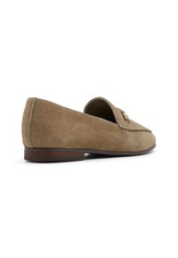 Mocassin en daim gris avec un bout arrondi, un petit accent en cuir marron et un petit talon en bois. Présente des coutures visibles le long des bords.