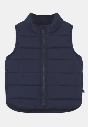 Veste sans manches matelassée bleu marine avec fermeture éclair à l'avant et col montant, conçue pour la chaleur et la superposition.
