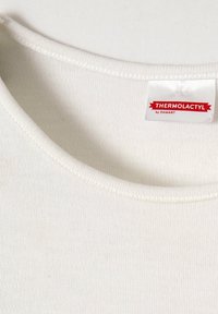 Witte thermoshirt met een ronde hals. Geweven stof met zichtbare stiksels. Label met de tekst "THERMOLACTYL by DAMART."