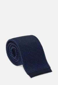 Stickad marinblå slips med en texturerad mönstring och ljusblå accenter. Slipsen är rullad, vilket visar dess släta kanter och vävda utseende.