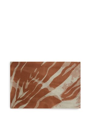 Tessuto rettangolare con strisce ondulate astratte in tonalità terracotta e beige, disteso su uno sfondo bianco.