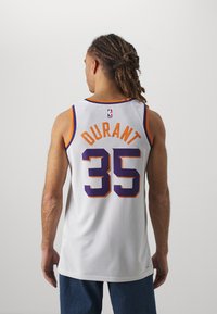 Maillot de basketball en maille blanche avec des accents violets et oranges, portant le nom "DURANT" et le numéro "35" à l'arrière. Design avec col rond solide.