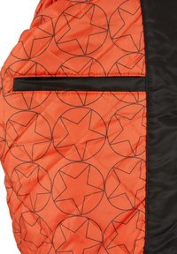 Jachetă matlasată din material portocalie, cu un model de stele negre, accentuată de un panou neted negru pe lateral și un buzunar cu fermoar.