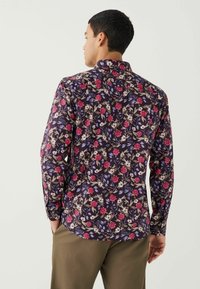 Langsleeve shirt met een donker bloemdesign met roze, witte en blauwe bloemen op een marineblauwe achtergrond; met kraag en knoopsluiting.