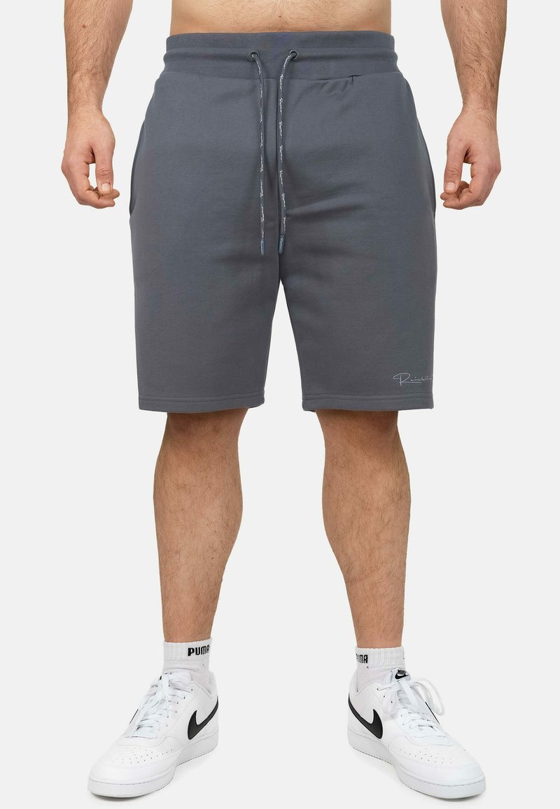 Grijze katoenen shorts in een katoenmix met een tailleband met trekkoord, zijzakken en logodetail. Gecombineerd met witte sneakers en crew sokken.