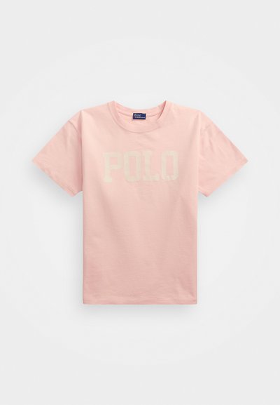Pink cotton t-shirt with short sleeves, featuring a large, cream-colored "POLO" text centered on the front. Ribbed crew neckline.
