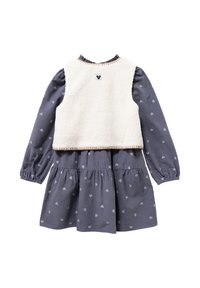 Chaleco de beige forrado de forro polar con un vestido gris de manga larga que presenta patrones de corazones plateados, falda de capas y un escote con volantes.