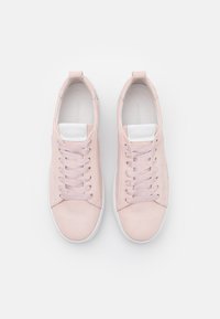 Różowe zamszowe sneakersy z białymi akcentami i teksturowanym wzorem sznurowadeł. Okrągły nosek i płaska gumowa podeszwa, z subtelnym logo na pięcie.