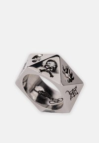 Metallring med et geometrisk design, med graveringer av hodeskalle, flamme og korsben. Polert sølvfinish som fremhever teksturerte detaljer.