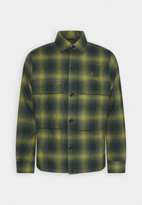 Grön rutigt flanellskjorta med gula accenter, med knappstängning framtill, två bröstfickor och en strukturerad krage.