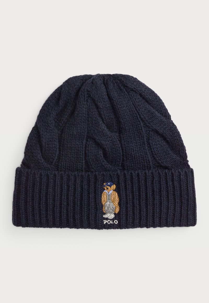 Navy knitted beanie with a cable knit design and ribbed cuff. Features an embroidered bear wearing a jacket and hat, labeled "Polo."
