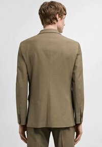 Khaki-Anzugjacke mit einem Schlitz, zwei Knöpfen und Reverskragen. Glattes Material mit subtiler Glanz und Knöpfen an den Ärmelabrechungen.