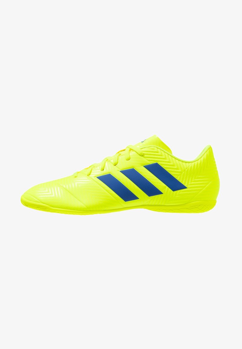Scarpe da calcio gialle con materiale testurizzato, accenti a strisce blu, design a profilo basso e suola in gomma con una presa a motivo.