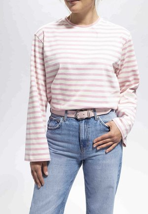 Haut à manches longues rayé rose et blanc associé à un jean en denim bleu taille haute et une ceinture rose clair, avec un col rond.
