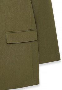 Olive krāsas žakete ar teksturētu audumu, piegriezumu, kas pielāgots figūrai, un vienu kabatu kreisajā pusē.