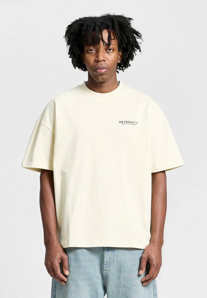 Lichtgele oversized katoen t-shirt met korte mouwen en een ronde hals. Kenmerkt zich door een zwart tekstlogo op de linkerborst.