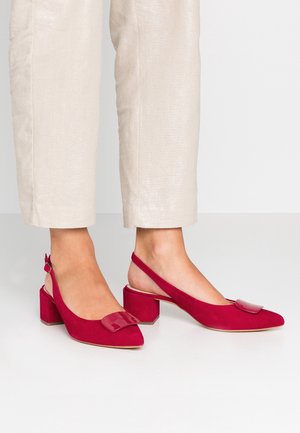 Chaussures slingback en daim rouge avec un bout pointu et un petit talon carré. Elles présentent un accent brillant sur la zone des orteils et une bride ajustable.