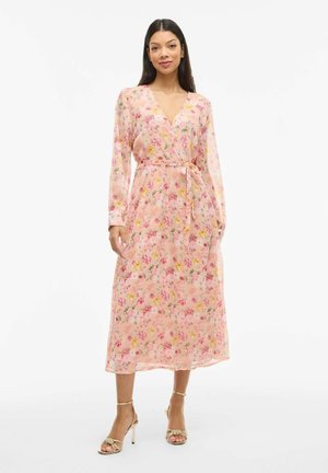 Abito maxi floreale in tessuto rosa trasparente con maniche lunghe, scollatura a V e vita con nastrini. Presenta motivi floreali multicolori e una silhouette fluida.