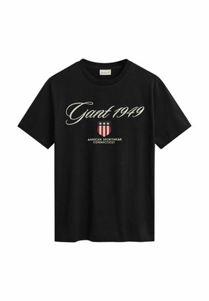 T-shirt in cotone nero con maniche corte, caratterizzata da un logo bianco in corsivo "Gant 1949" e una grafica a forma di scudo rossa con stelle sottostante.