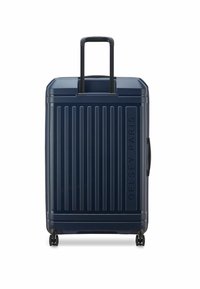 Valigia rigida blu navy con strisce verticali, maniglia superiore e quattro ruote per la mobilità. Presenta il nome del marchio embosso lato.
