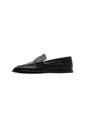 Mocassin en cuir noir avec une finition texturée, semelle plate et une bride penny traditionnelle sur le dessus, montré de profil.