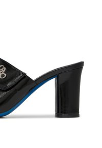 Mule aperto in pelle verniciata nera con tacco a blocco, caratterizzato da una suola blu e un risvolto decorativo con dettagli hardware sulla parte superiore.