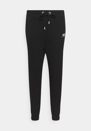 Pantalons de jogging noirs avec une taille élastique à cordon de serrage, design de jambe fuselée, poignets côtelés et détail de logo blanc sur la cuisse. Texture de tissu douce.