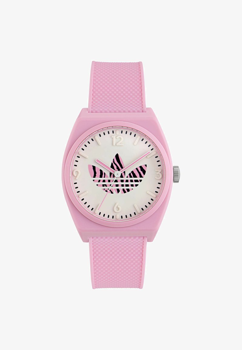 Rozā gumijas pulkstenis ar kvadrātveida korpusu, baltu ciparnīcu un melnu zebras rakstu. Ar rozā stundu un minūšu rādītājiem, kā arī teksturētu siksniņu.