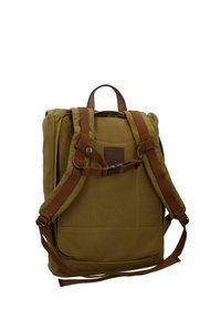 Sac à dos en toile marron avec des accents en cuir, des bretelles réglables, une poignée supérieure et une poche zippée à l'avant. Surface texturée avec des détails de couture.