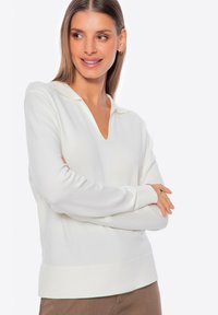Biały długi rękaw sweter z dekoltem w serek i kołnierzykiem, charakteryzujący się miękką teksturą i dopasowanym krojem. Prosty design bez widocznych wzorów.