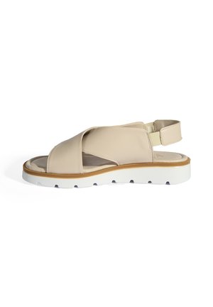 Beige leather sandal with cross-strap design, adjustable heel strap, and white rubber sole featuring a textured tread for grip.