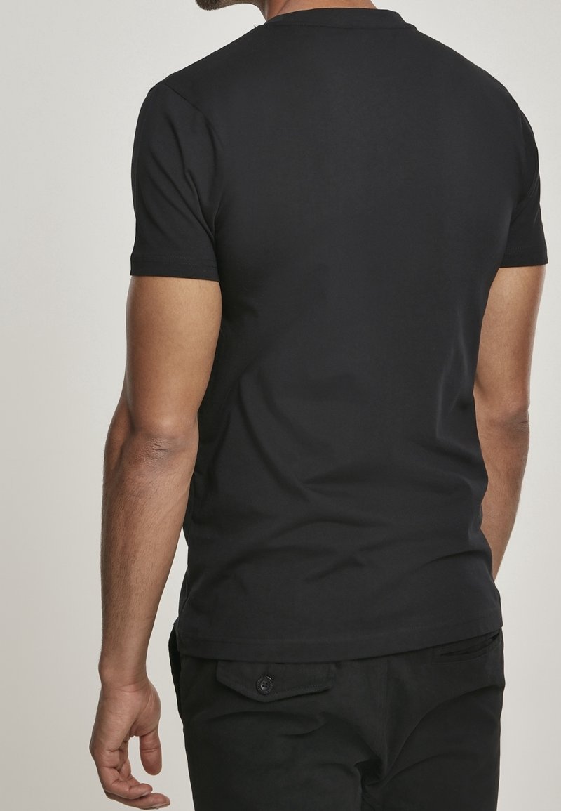 Svart kortärmad T-shirt i slät bomull, med rund hals och minimalistisk design, visad på en person bakifrån.