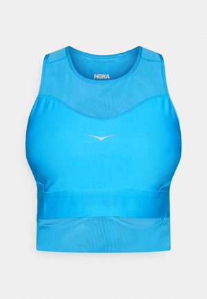 Blue athletic crop top with a smooth, stretch fabric. Features a rounded neckline and minimalistic logo detail in the center.