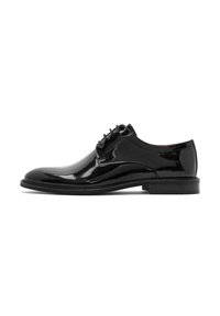 Chaussure de ville en cuir verni noir avec un bout arrondi, des coutures minimales, six œillets et une semelle en caoutchouc plate.